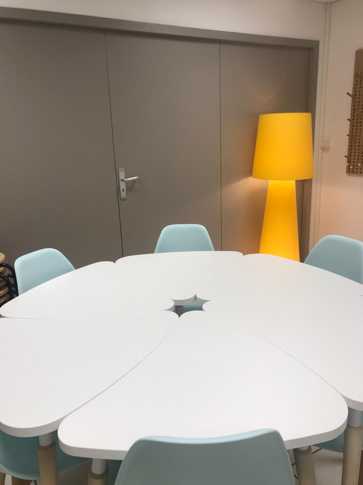Grand lampadaire jaune dans une salle de rÃ©union aux tables blanches