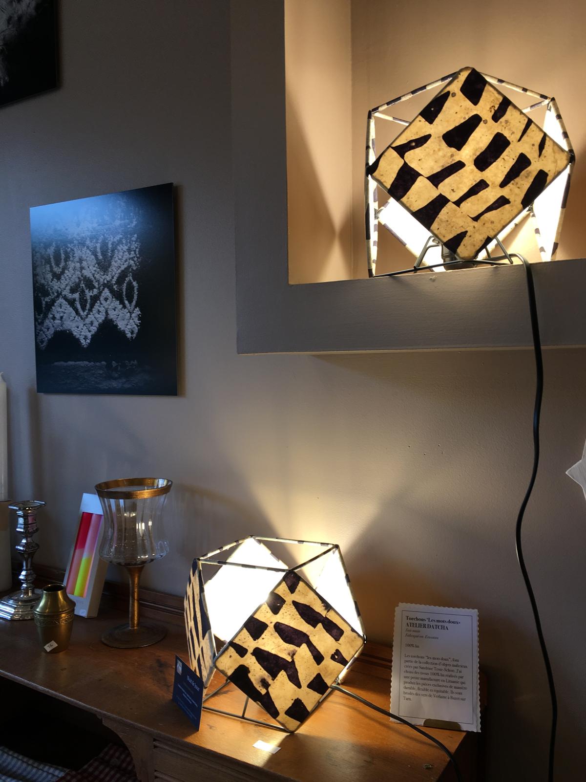 Deux lampes sculpturales Ã©clairÃ©es avec motifs sombres dans un intÃ©rieur chaleureux