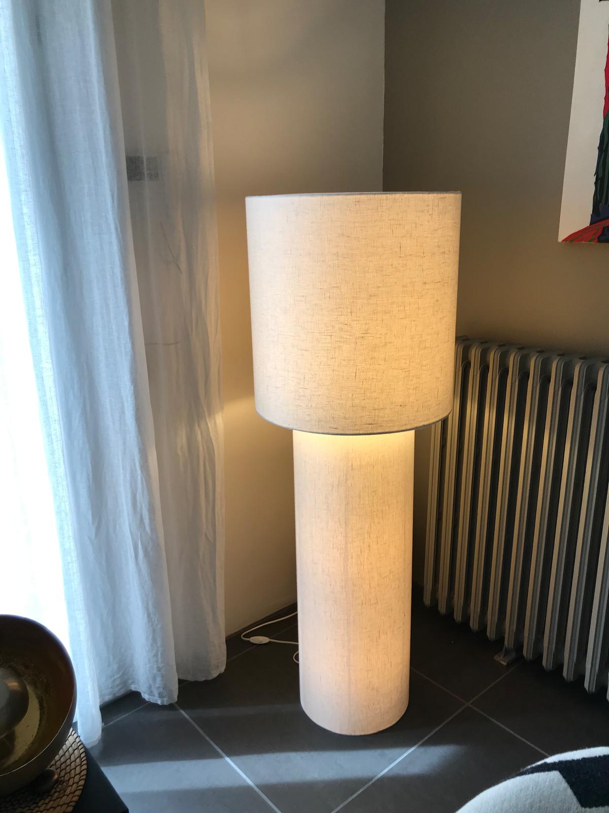 Grand lampadaire clair Ã  double cylindre allumÃ© prÃ¨s d'un rideau blanc