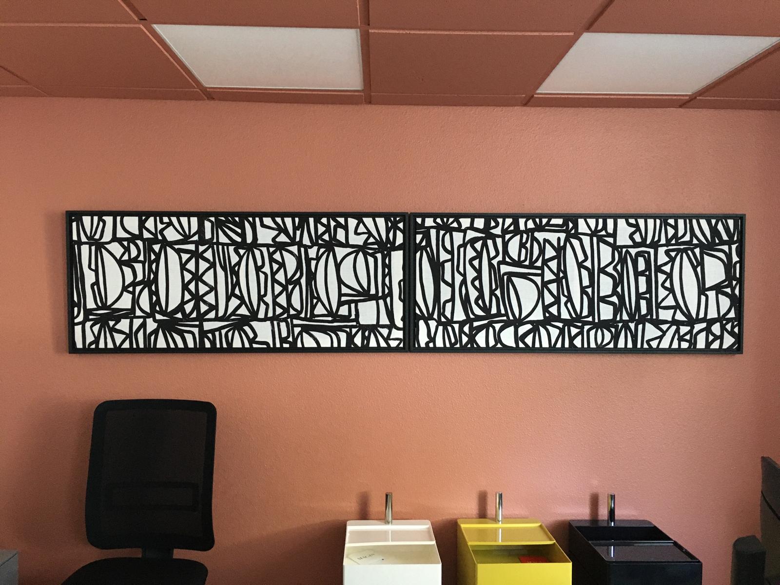 Diptyque mural noir et blanc à graphisme abstrait installé dans un bureau