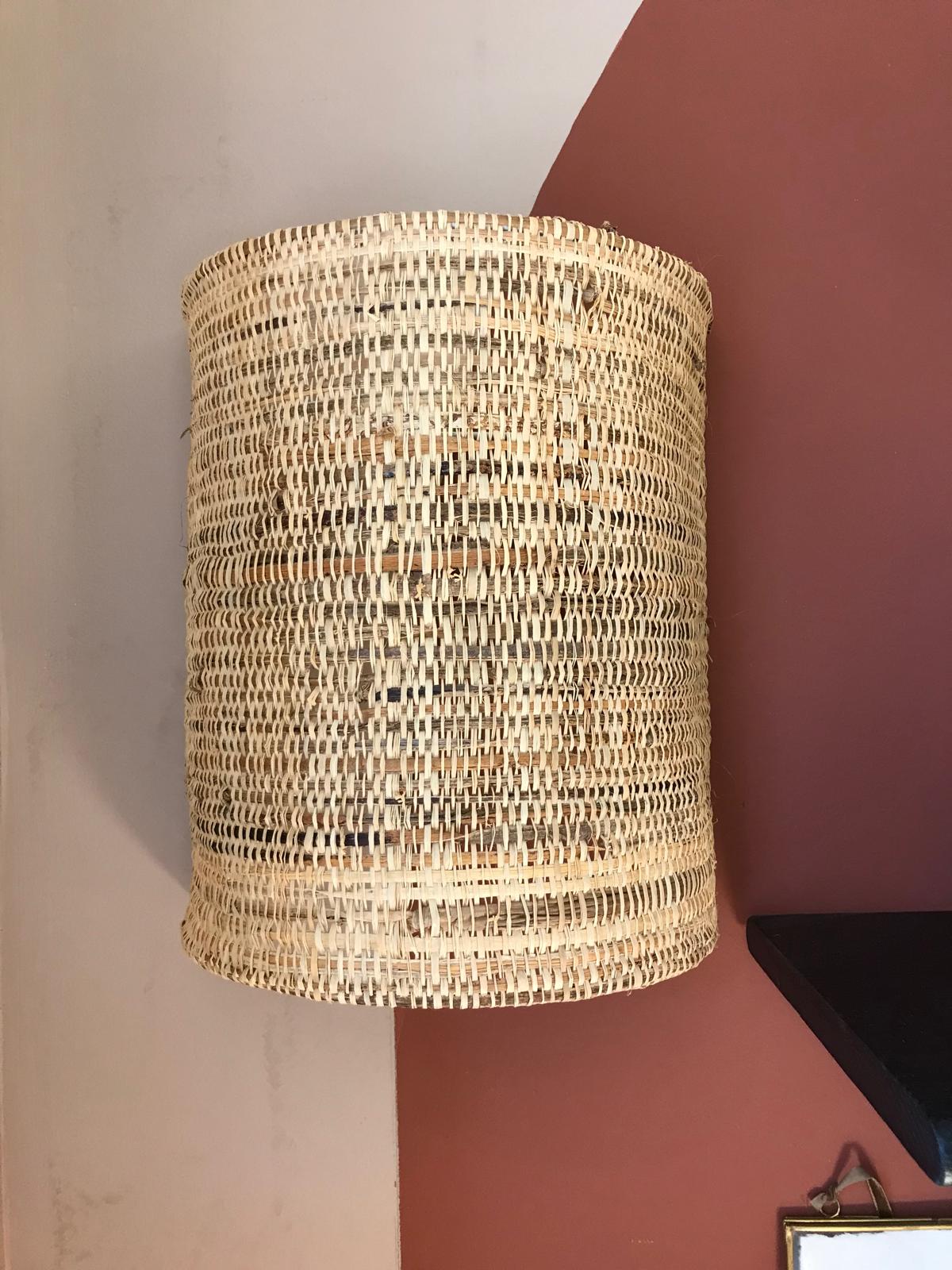 Applique cylindrique tressée en fibre naturelle fixée sur un mur bicolore