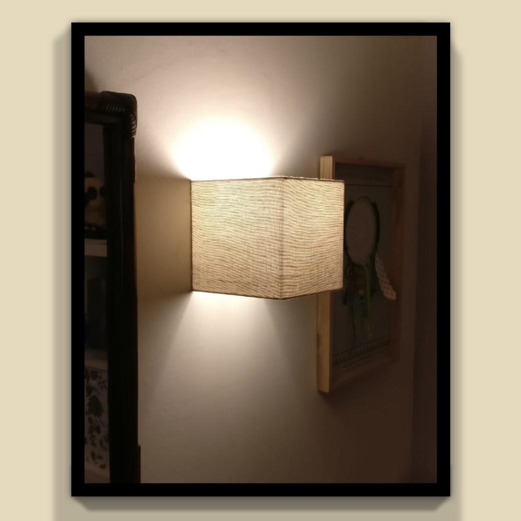 Applique carrée allumée diffusant une lumière douce dans un couloir