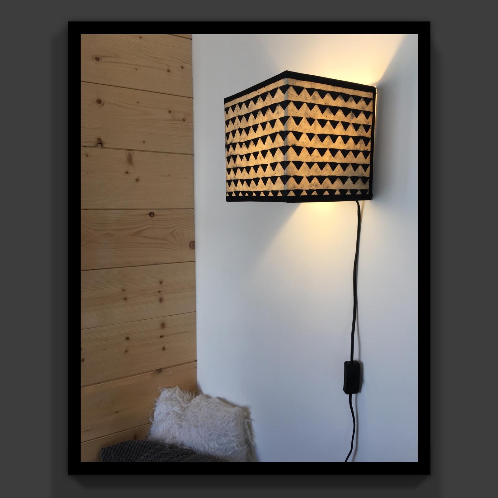 Applique carrée avec motif triangulaire noir et lumière chaude