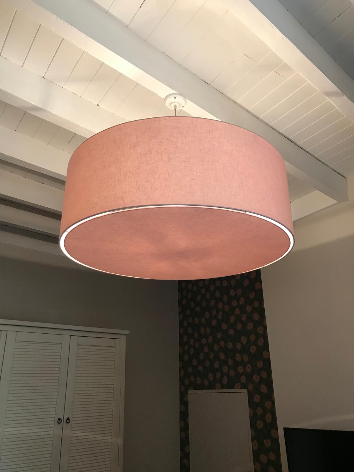Grande suspension rose poudré sous poutres blanches