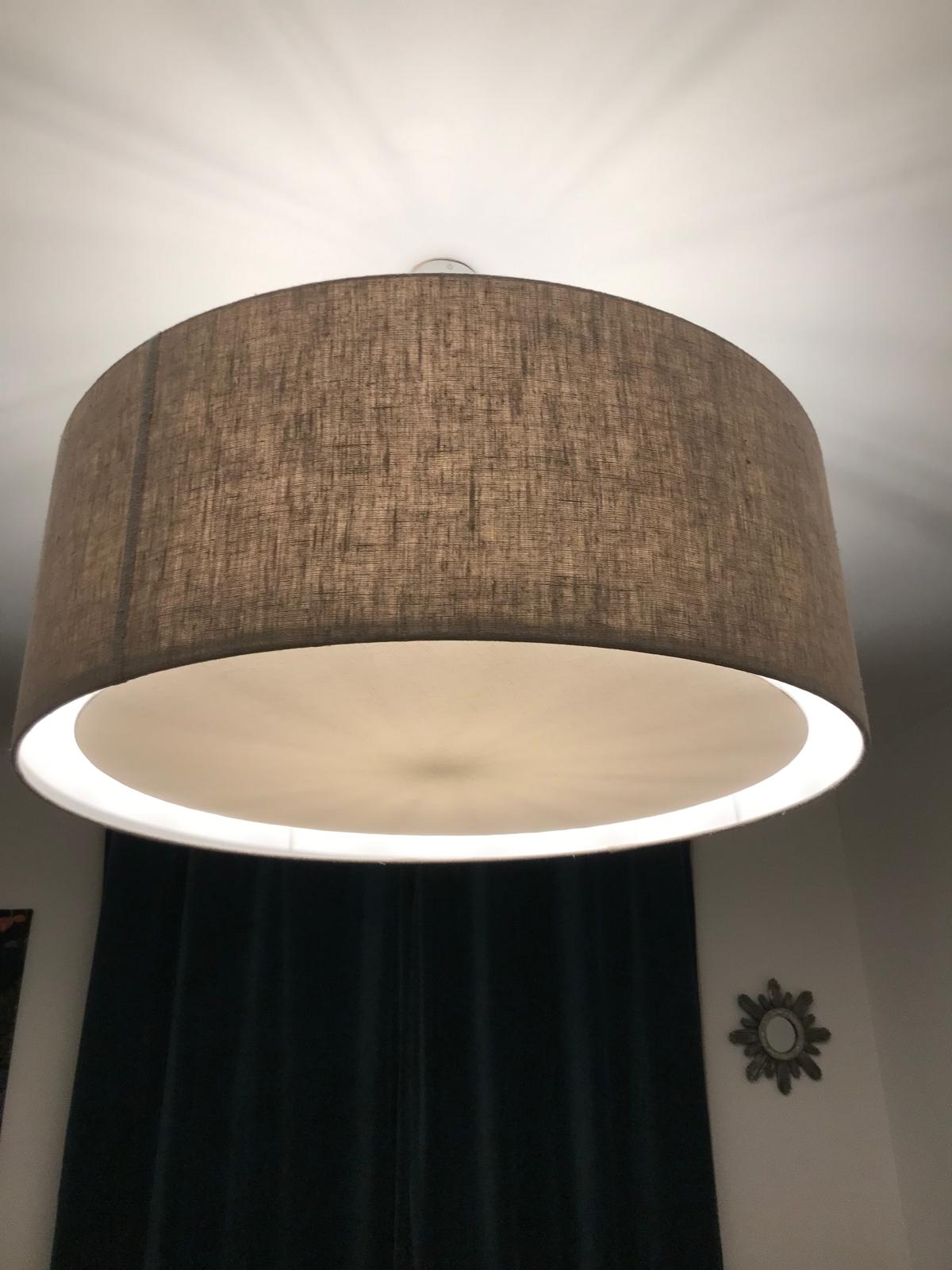 Suspension taupe cylindrique diffusant un halo lumineux sur le plafond